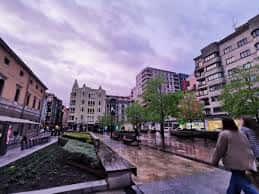 Vista panorámica de la Plaza del Instituto en Gijón bajo un cielo de atardecer