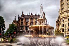 Fuente ornamental en una plaza céntrica de Bilbao con edificios de arquitectura clásica al fondo