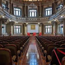 Salón de actos y conferencias con hileras de asientos y escenario