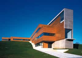 Vista exterior del Edificio Impulsa destacando su arquitectura moderna en madera y hormigón bajo un cielo despejado