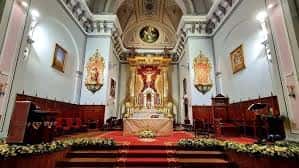 Perspectiva del altar mayor con su retablo dorado y la decoración floral del presbiterio