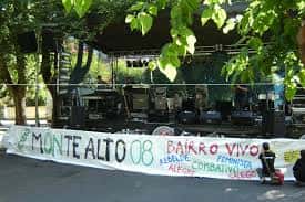 Escenario de concierto al aire libre con pancarta conmemorativa de la asociación vecinal
