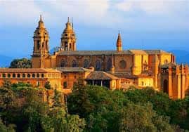 Vista panorámica de la Catedral de Pamplona rodeada de vegetación bajo la luz del atardecer