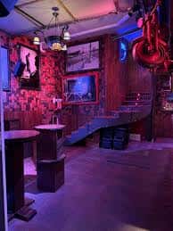 Interior del local con iluminación ambiental en tonos púrpuras y decoración temática