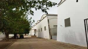 Perspectiva exterior de los pabellones blancos y zona de acceso del centro logístico