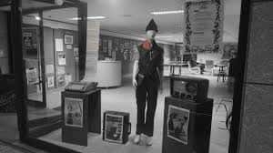 Vista del interior del local con una exposición de objetos y carteles culturales