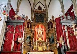 Vista del retablo mayor y el presbiterio en el interior del templo