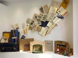 Decoración artística de pared con libros abiertos y maquetas en el taller