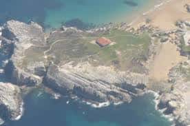 Vista aérea de la Isla de la Virgen del Mar y su ermita rodeada por el mar Cantábrico