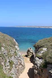 Pasaje entre acantilados con vistas a las aguas cristalinas de la costa de Santander