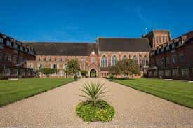 Vista frontal del edificio principal de Ardingly College con jardines y camino de grava