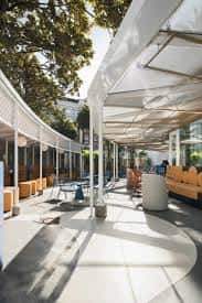 Espacio diáfano en la terraza cubierta con estructura metálica blanca y diseño contemporáneo