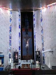 Interior del templo con vista al altar mayor, el gran crucifijo y las vidrieras laterales