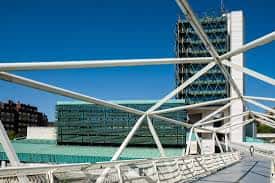 Estructura del puente peatonal con la torre del museo al fondo bajo un cielo despejado