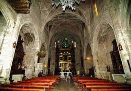 Perspectiva del interior del templo con arcos apuntados y bancos para los asistentes