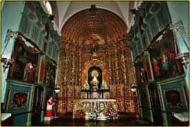 Retablo mayor ornamentado en tonos dorados presidiendo el altar principal