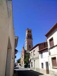 Perspectiva de la torre mudéjar de la iglesia sobresaliendo entre las calles del entorno