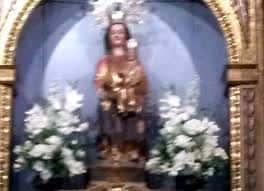 Imagen de la Virgen en el interior del templo con ornamentación floral