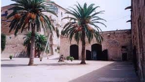 Plaza interior de Ses Voltes con palmeras y arquitectura tradicional de piedra