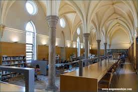 Interior de la biblioteca con arcos apuntados y columnas de piedra