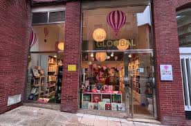 Fachada de ladrillo de la librería con escaparates decorados y globos aerostáticos de papel