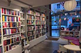 Pasillo interior de la librería con estanterías llenas de libros y vista hacia la entrada