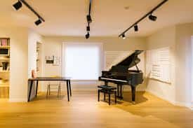 Sala principal de la escuela con piano de cola y sistema de iluminación profesional
