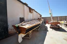 Barca de madera en el área de trabajo exterior de los astilleros