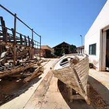 Estructuras de madera y restos de embarcaciones en el patio del astillero
