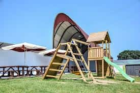 Área de juegos de madera y mesas de picnic en el espacio exterior