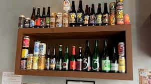 Estantería interior con una variada colección de botellas y latas de cerveza
