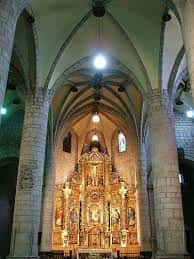 Interior del templo mostrando el retablo mayor y las bóvedas de crucería