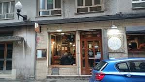 Fachada de piedra del restaurante con puerta de madera y grandes ventanales