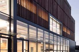 Detalle de la fachada moderna del edificio Bilbao AS Fabrik con grandes ventanales y estructura de madera