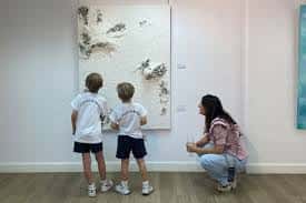 Niños contemplando una obra de arte en relieve en una de las salas del taller