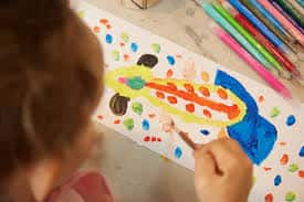 Detalle de un niño realizando una actividad de pintura creativa