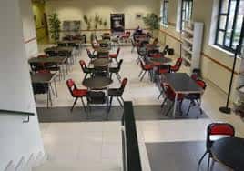 Interior del centro social con disposición de mesas y sillas para reuniones