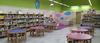 Interior de la sección infantil con mobiliario colorido y estanterías de libros