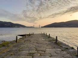 Muelle de piedra tradicional con vistas a la ensenada y el puente de Rande al fondo