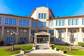 Fachada principal y entrada del Gran Hotel Los Abetos bajo un cielo despejado