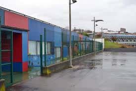 Vista de la zona exterior y fachada moderna con paneles de colores de la escuela infantil