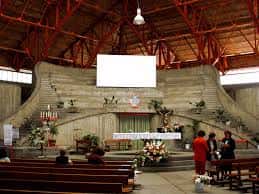 Interior del templo con vista al altar y la disposición de los bancos para los asistentes