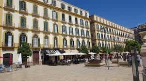 Fachadas de edificios históricos con arquitectura tradicional y terrazas en la Plaza de la Merced