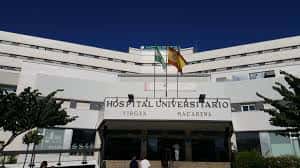 Entrada principal del Hospital Universitario Virgen Macarena con el rótulo del centro y banderas