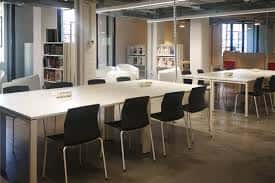 Vista del interior de la Biblioteca Municipal de Basurto con amplias mesas de estudio y estanterías