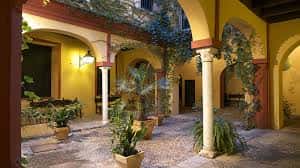 Patio interior con columnas de mármol y decoración tradicional sevillana
