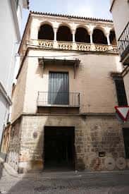 Fachada exterior del edificio histórico con balconada y arcos