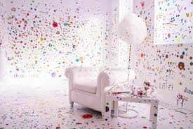 Habitación blanca decorada con puntos de colores y mobiliario minimalista