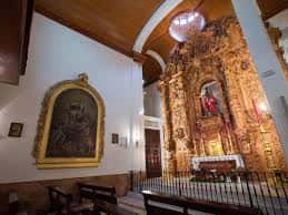 Interior de la capilla mostrando uno de los altares laterales y la techumbre de madera