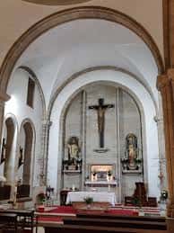 Vista del altar mayor en el interior de la iglesia con el crucifijo y retablos laterales